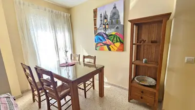 a dining room with a wooden table and a window at Chocita del Botánico Pet Friendly by Sanlúcar Housing in Sanlúcar de Barrameda