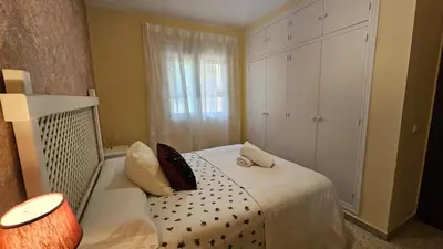 a small bedroom with a bed and a window at Chocita del Botánico Pet Friendly by Sanlúcar Housing in Sanlúcar de Barrameda