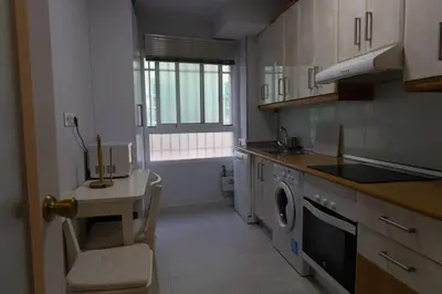 a kitchen with a washing machine and a table and a sink at El Caletero by Gades Gestión in Cádiz