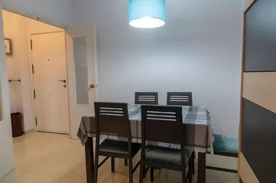 a dining room table with four chairs and a blue light at El Caletero by Gades Gestión in Cádiz