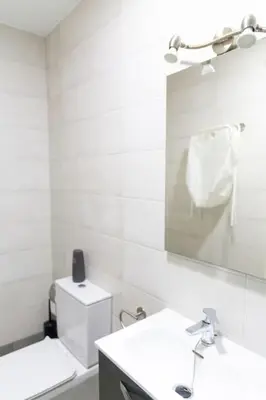 a white bathroom with a sink and a mirror at El Caletero by Gades Gestión in Cádiz