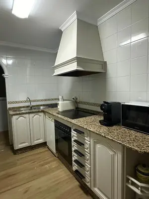 a kitchen with white cabinets and a counter top at Casita de la playa en Durango in El Puerto de Santa María