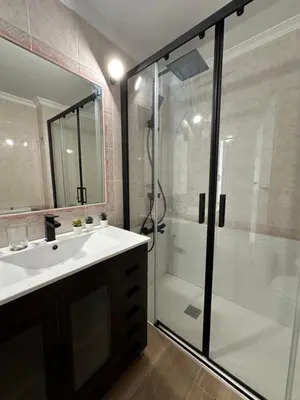 a bathroom with a white sink and a shower at Casita de la playa en Durango in El Puerto de Santa María