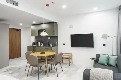 a kitchen and a dining room with a table and chairs at Limehome Jerez de la Frontera Marqués de Casa-Domecq in Jerez de la Frontera
