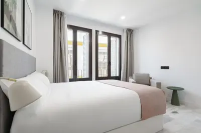 a white bedroom with a large bed and windows at Limehome Jerez de la Frontera Marqués de Casa-Domecq in Jerez de la Frontera