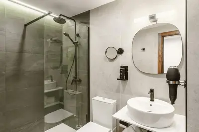 a bathroom with a shower and a sink and a mirror at Limehome Jerez de la Frontera Marqués de Casa-Domecq in Jerez de la Frontera