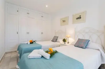 a bedroom with two beds with flowers on them at Vistahermosa Piscina Vistas in El Puerto de Santa María