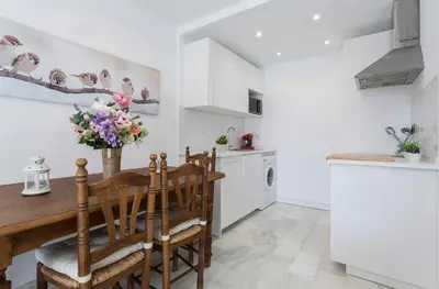 a kitchen with a wooden table and chairs at Vistahermosa Piscina Vistas in El Puerto de Santa María