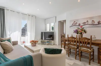 a living room with a couch and a dining room at Vistahermosa Piscina Vistas in El Puerto de Santa María