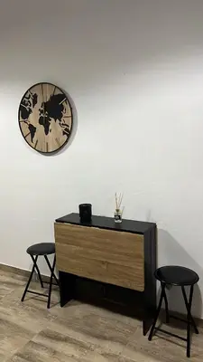 a dresser with two stools and a clock on a wall at Apartamento Empedrado in Jerez de la Frontera