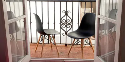 two chairs sitting on a balcony next to a gate at CDZ - Carmen Coronada in Cádiz
