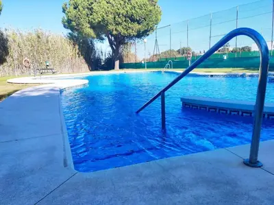 a swimming pool with a slide in the water at Apartamento Di Matteo, Playa-Piscina in Sanlúcar de Barrameda