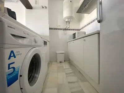 a washer and dryer in a white laundry room at Apartamento Di Matteo, Playa-Piscina in Sanlúcar de Barrameda