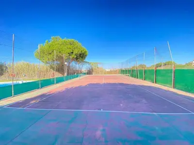 a tennis court with a net on top of it at Apartamento Di Matteo, Playa-Piscina in Sanlúcar de Barrameda