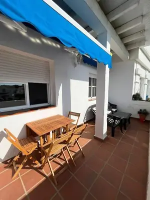 a patio with a wooden table and chairs on a roof at Apartamento Di Matteo, Playa-Piscina in Sanlúcar de Barrameda
