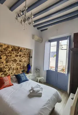 a bedroom with a bed and a blue door at La casa vertical in Cádiz