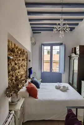 a bedroom with a large white bed and a window at La casa vertical in Cádiz