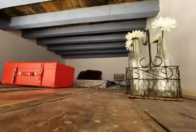 a red suitcase and a vase with flowers in it at La casa vertical in Cádiz