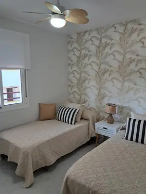 a living room with two beds and a couch at PLAYA PASEO MARITIMo in Sanlúcar de Barrameda