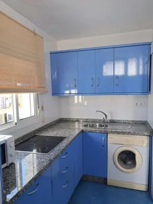 a blue kitchen with a sink and a washing machine at PLAYA PASEO MARITIMo in Sanlúcar de Barrameda