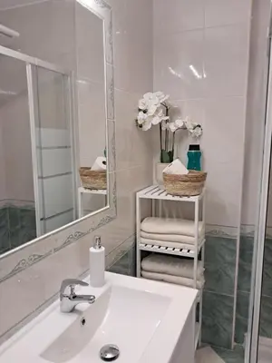 a white bathroom with a sink and a mirror at PLAYA PASEO MARITIMo in Sanlúcar de Barrameda