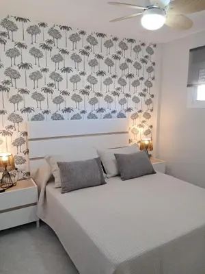 a bedroom with a bed and a wall with umbrellas at PLAYA PASEO MARITIMo in Sanlúcar de Barrameda