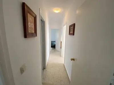 a hallway with two pictures on the walls of a room at Apartamento Parque Bolsa in Sanlúcar de Barrameda