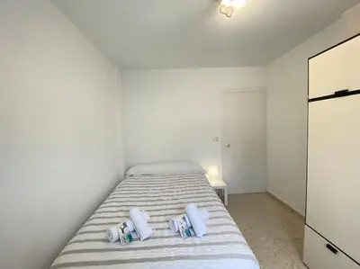 a bedroom with a bed with white sheets and pillows at Apartamento Parque Bolsa in Sanlúcar de Barrameda