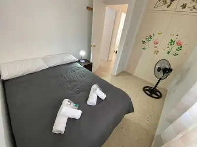 a bedroom with a bed with two towels on it at Apartamento Parque Bolsa in Sanlúcar de Barrameda