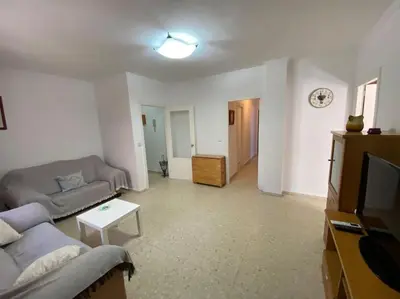 a living room with a couch and a tv at Apartamento Parque Bolsa in Sanlúcar de Barrameda