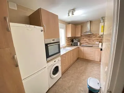 a kitchen with a refrigerator and a washing machine at Apartamento Parque Bolsa in Sanlúcar de Barrameda