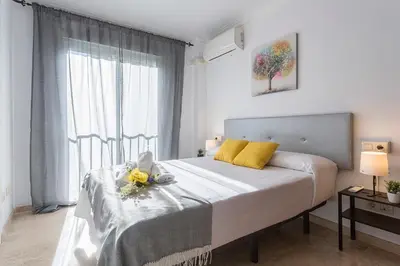 a white bedroom with a bed with flowers on it at Amplio y Luminoso 3 Rooms Parking in Jerez de la Frontera