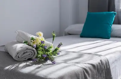 a bouquet of flowers sitting on top of a bed at Amplio y Luminoso 3 Rooms Parking in Jerez de la Frontera