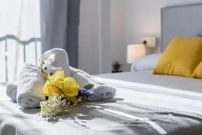 a hotel room with towels and flowers on a bed at Amplio y Luminoso 3 Rooms Parking in Jerez de la Frontera