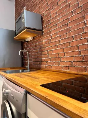a kitchen with a brick wall and a counter top at Estudio Casa Palacio 2Pax wifi gratis in Sanlúcar de Barrameda