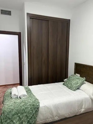 a bed with a wooden headboard and two pillows on it at Villa jiguera in Cádiz
