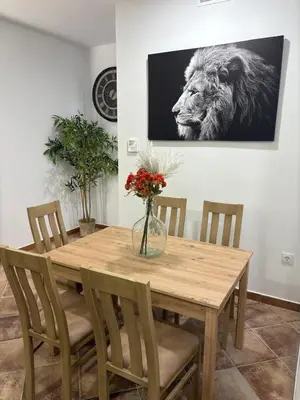 a dining room table with a lion picture on the wall at Villa jiguera in Cádiz