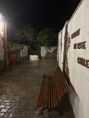 a wooden bench sitting next to a wall at night at Villa jiguera in Cádiz