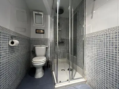 a bathroom with a toilet and a glass shower at Little Cadiz Grupo AC Gestion in Cádiz