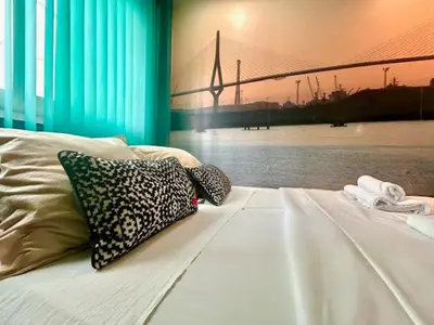 a bed with two pillows on it next to a bridge at GATU Exótica , 