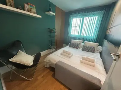 a bedroom with a bed with a chair and a window at GATU Exótica , 