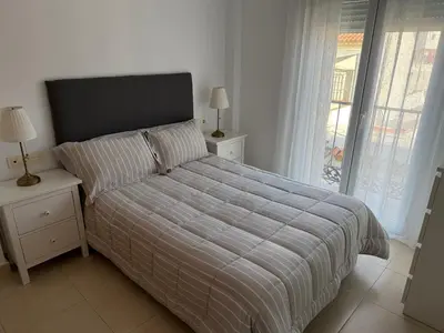 a bedroom with a bed with a striped bedspread at Piso completo en Chiclana de la Frontera in Chiclana de la Frontera