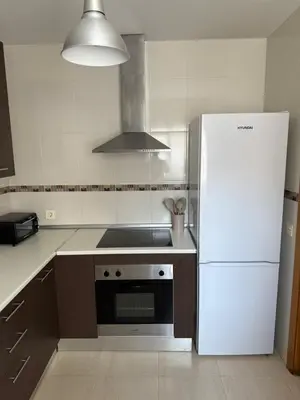a kitchen with a white refrigerator and a stove at Piso completo en Chiclana de la Frontera in Chiclana de la Frontera