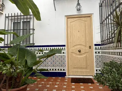 a wooden door in a building with plants at Apartamento Santa Clara - Ole Solutions in Jerez de la Frontera