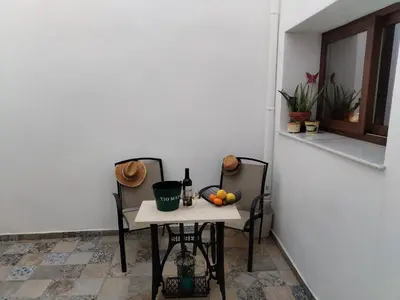 a table with a bottle of wine and fruit on it at Patio & Sherry Apartamento in Jerez de la Frontera