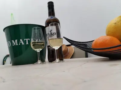 a bottle of wine and two glasses on a table at Patio & Sherry Apartamento in Jerez de la Frontera
