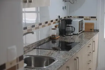 a kitchen counter with a sink and a coffee maker at Apartamento Ficus junto a la playa Cádiz in Cádiz