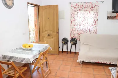 a dining room with a table and chairs and a door at Chalet Mendoza in Conil de la Frontera