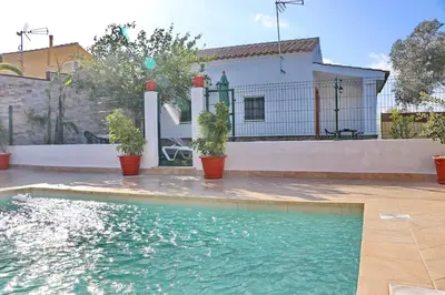 a swimming pool in front of a house at Chalet Mendoza in Conil de la Frontera