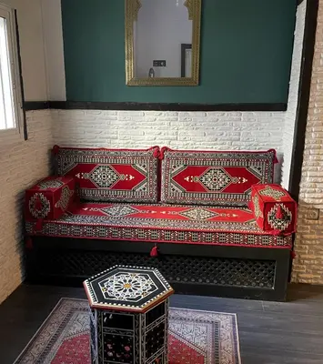 a red couch in a room with a table at Apartamento Plaza del Cabildo - Sanlúcar Centro in Sanlúcar de Barrameda